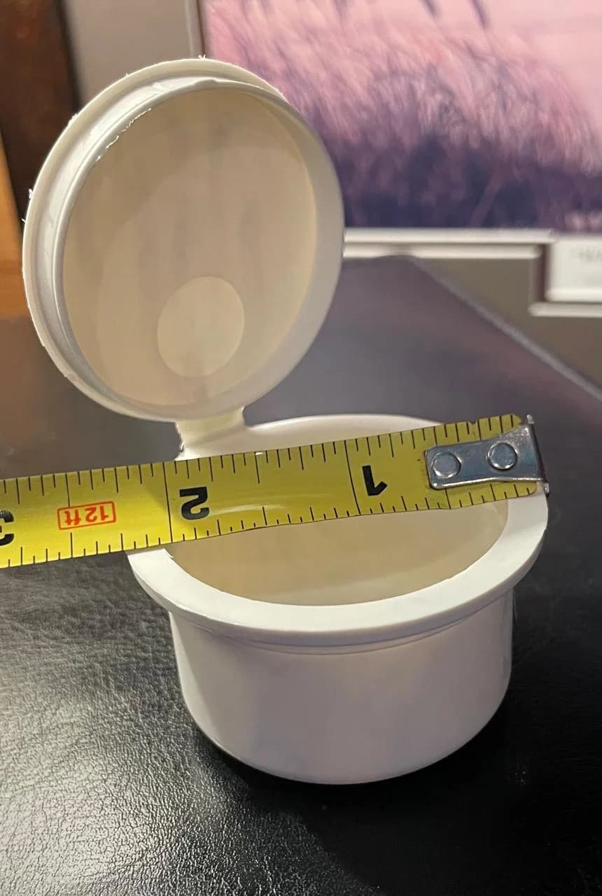 PHA pop top container measured for diameter with a tape measure